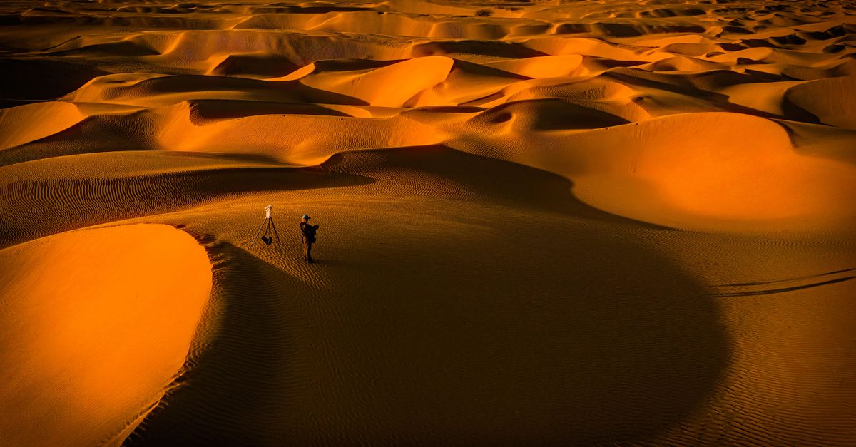 Roadtrip en Tunisie : entre désert, histoire et souvenirs entre amis A mesmerizing aerial shot capturing the vastness and beauty of desert dunes at sunset.